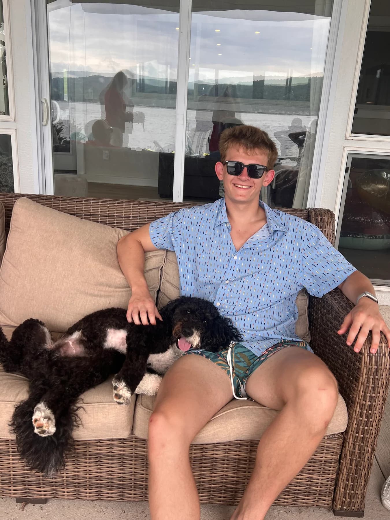 Person seated outdoors with Frank, a black-and-white dog